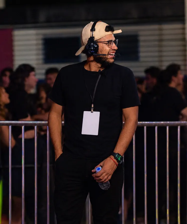 Jefferson Machado coordenando a produção de um evento, com headset e credencial